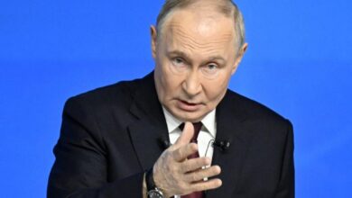 Ο Βλαντίμιρ Πούτιν στο βήμα της ετήσιας συνέντευξης Τύπου με φόντο τη ρωσική σημαία.