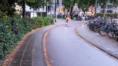 Άνθρωποι στην Ολλανδία που κάνουν ποδήλατο στη βροχή χωρίς ομπρέλα φορώντας αδιάβροχα