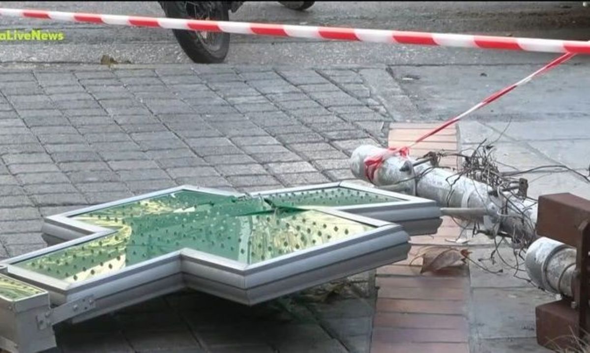 Σπασμένη μεταλλική κολώνα με διαφημιστικές πινακίδες και σταυρό φαρμακείου πεσμένη στο πεζοδρόμιο στην Κυψέλη