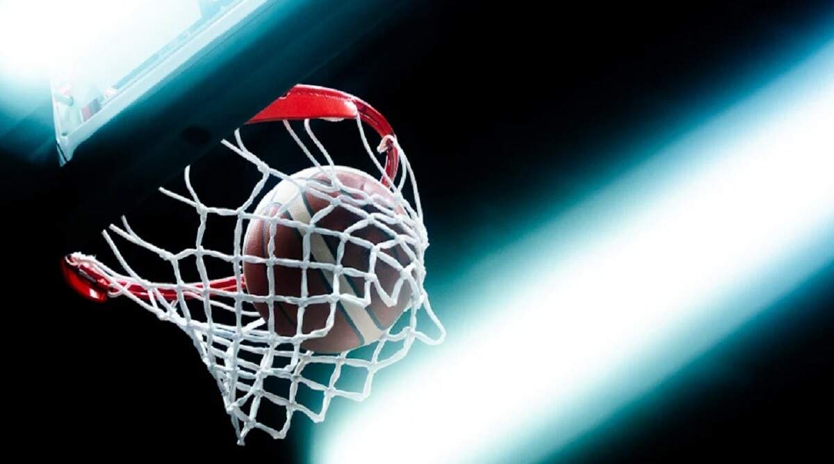 Μια μοναχική μπάλα μπάσκετ σε άδειο παρκέ υπό χαμηλό φωτισμό