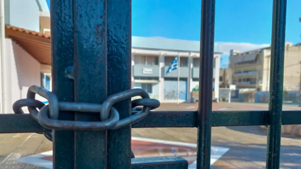 Χιονισμένο σχολικό προαύλιο με κλειστές πόρτες και έντονη χιονόπτωση, που απεικονίζει την αναστολή λειτουργίας των σχολικών μονάδων λόγω καιρικών συνθηκών