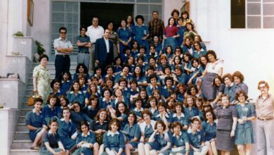 Μαθήτριες με μπλε σχολικές ποδιές και λευκούς γιακάδες σε σχολική αυλή