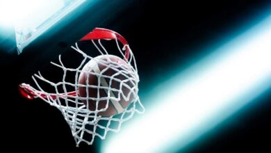 Μια μοναχική μπάλα μπάσκετ σε άδειο παρκέ υπό χαμηλό φωτισμό