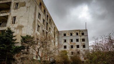 Το εγκαταλελειμμένο κτίριο του Σανατορίου στην Πάρνηθα με γκράφιτι στους τοίχους και φόντο το δάσος