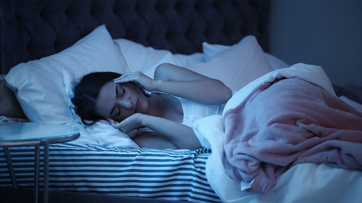 Άτομο που κινείται έντονα στο κρεβάτι κατά τη διάρκεια του ύπνου λόγω διαταραχής REM ενώ βλέπει όνειρο