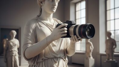 Αρχαιοελληνικό άγαλμα που κρατάει μια σύγχρονη κάμερα, συμβολίζοντας τη σύνδεση της ελληνικής γλώσσας με την τεχνολογία και τη λέξη μαγνητοσκόπιο