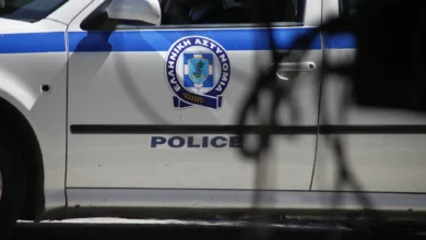 Περιπολικό της αστυνομίας και κορδέλες σήμανσης σε σημείο ερευνών, αντιπροσωπευτικό της τραγωδίας στη Λέρο