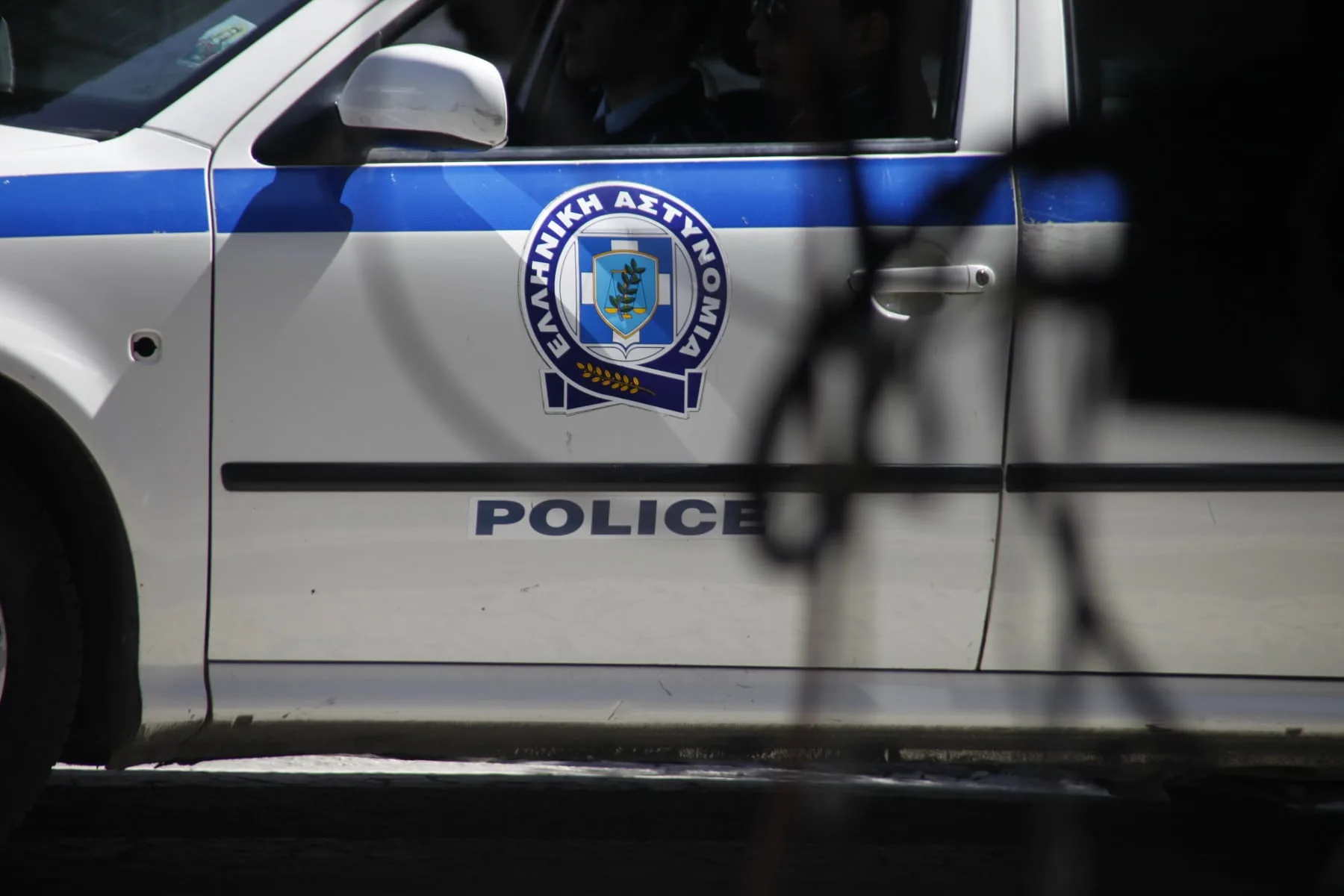 Περιπολικό της αστυνομίας και κορδέλες σήμανσης σε σημείο ερευνών, αντιπροσωπευτικό της τραγωδίας στη Λέρο