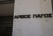 Το κτίριο του Αρείου Πάγου και σφυρί δικαστή πάνω από έγγραφα δανείων