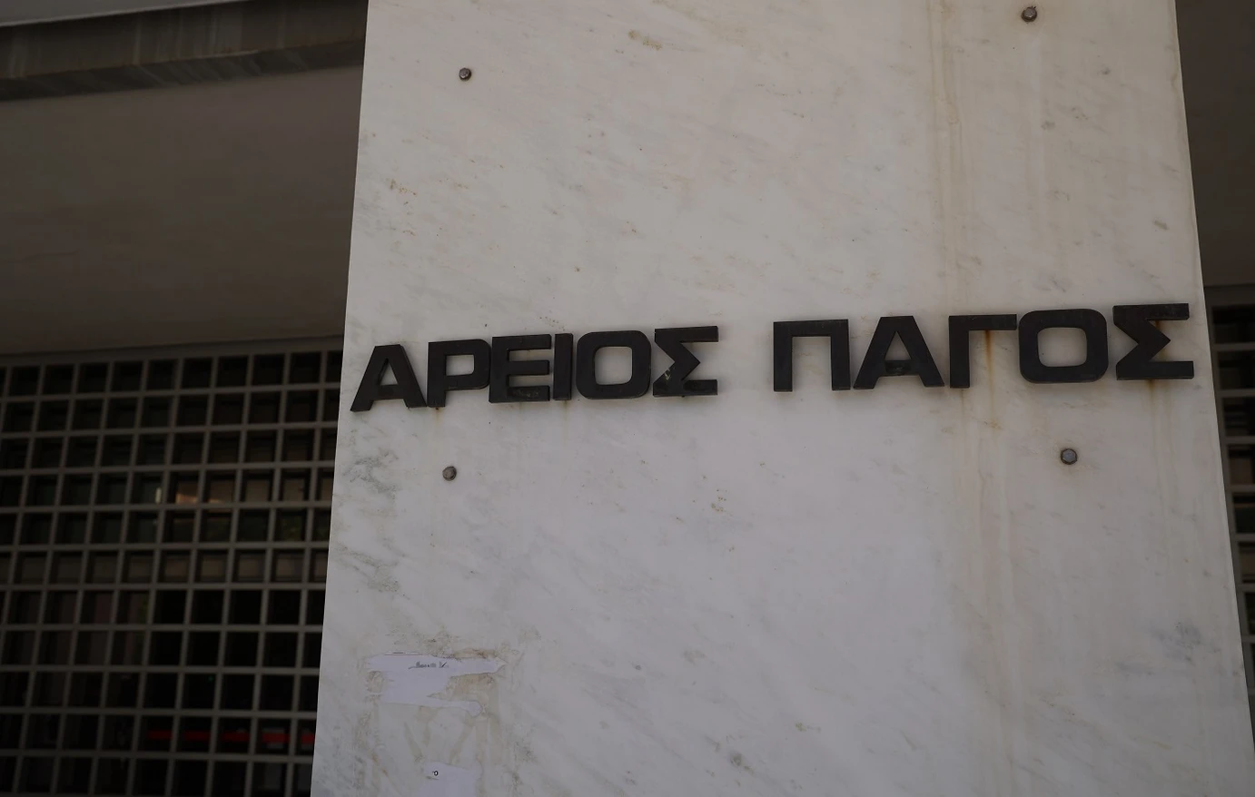 Το κτίριο του Αρείου Πάγου και σφυρί δικαστή πάνω από έγγραφα δανείων
