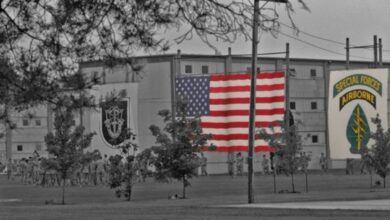 Ο Τζο Κεντ, επικεφαλής της αντιτρομοκρατικής υπηρεσίας των ΗΠΑ, σε φόντο με τη σημαία των ΗΠΑ και του Ιράν