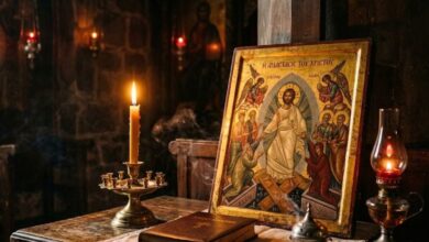 Αναμμένο κερί και εικόνα σε κατανυκτική ατμόσφαιρα, συμβολίζοντας την πνευματική γέφυρα ανάμεσα στους ζωντανούς και τους κεκοιμημένους