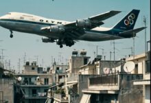 Αναπαράσταση του Boeing 747 της Ολυμπιακής να πετά σε χαμηλό ύψος πάνω από τις πολυκατοικίες στην Καλλιθέα