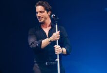 Ο Νίκος Οικονομόπουλος τραγουδάει στη σκηνή και πλησιάζει μια θαμώνα.