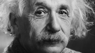 Ο Άλμπερτ Αϊνστάιν χαμογελαστός με φόντο έναν μαυροπίνακα, συμβολίζοντας τη δημιουργική ευφυΐα