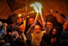Ο Πατριάρχης Ιεροσολύμων κρατά τις 33 αναμμένες λαμπάδες με το Άγιο Φως έξω από τον Πανάγιο Τάφο