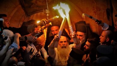 Ο Πατριάρχης Ιεροσολύμων κρατά τις 33 αναμμένες λαμπάδες με το Άγιο Φως έξω από τον Πανάγιο Τάφο