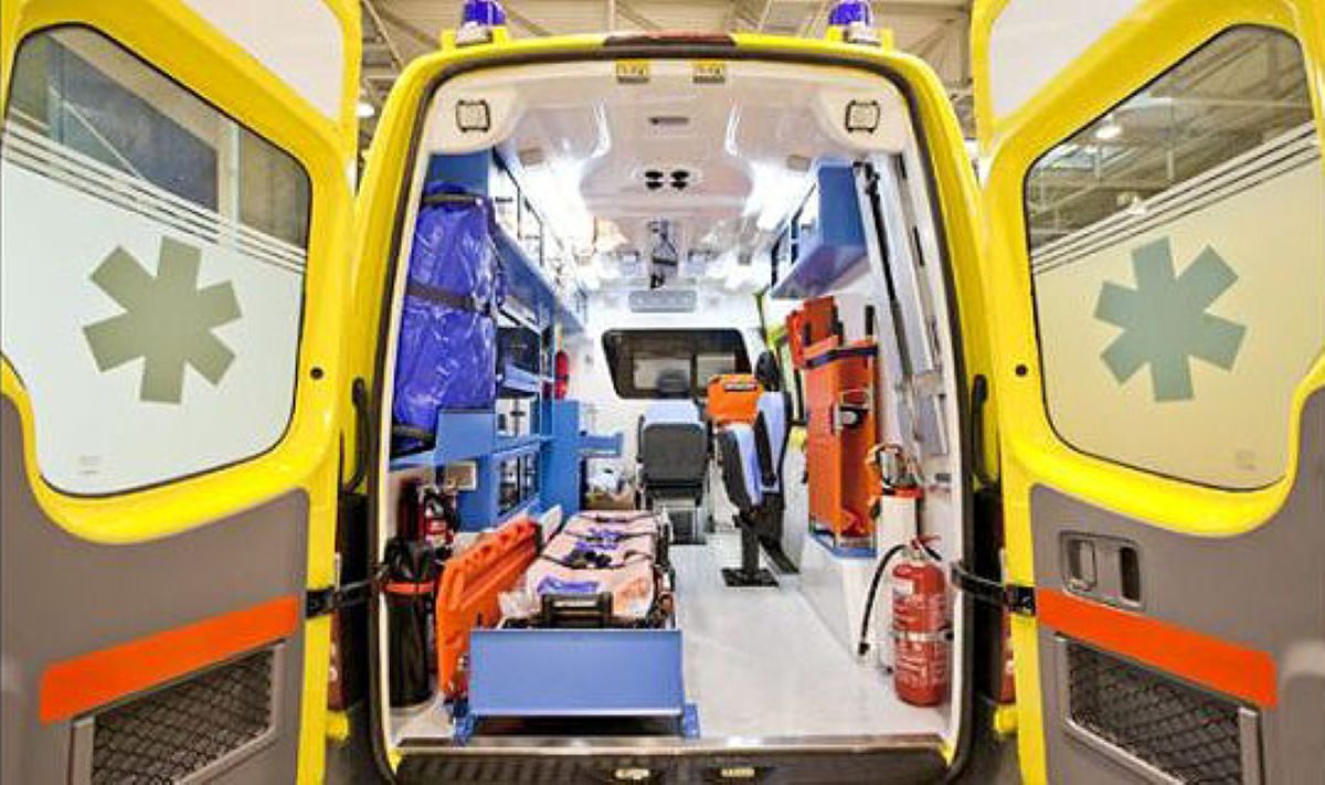 Ασθενοφόρο του ΕΚΑΒ με φόντο την πόλη των Τρικάλων σε κλίμα πένθους.