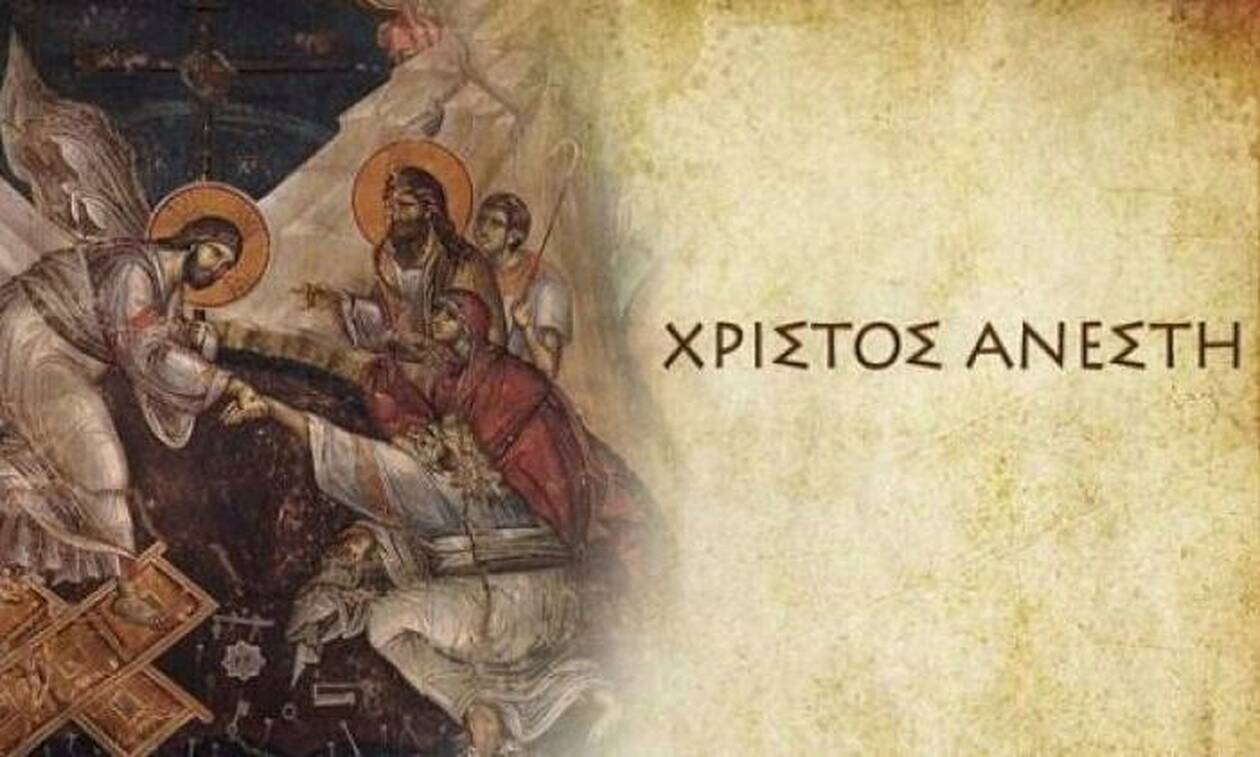 Το Άγιο Φως από μια πασχαλινή λαμπάδα με φόντο το "Χριστός Ανέστη" στην εκκλησία