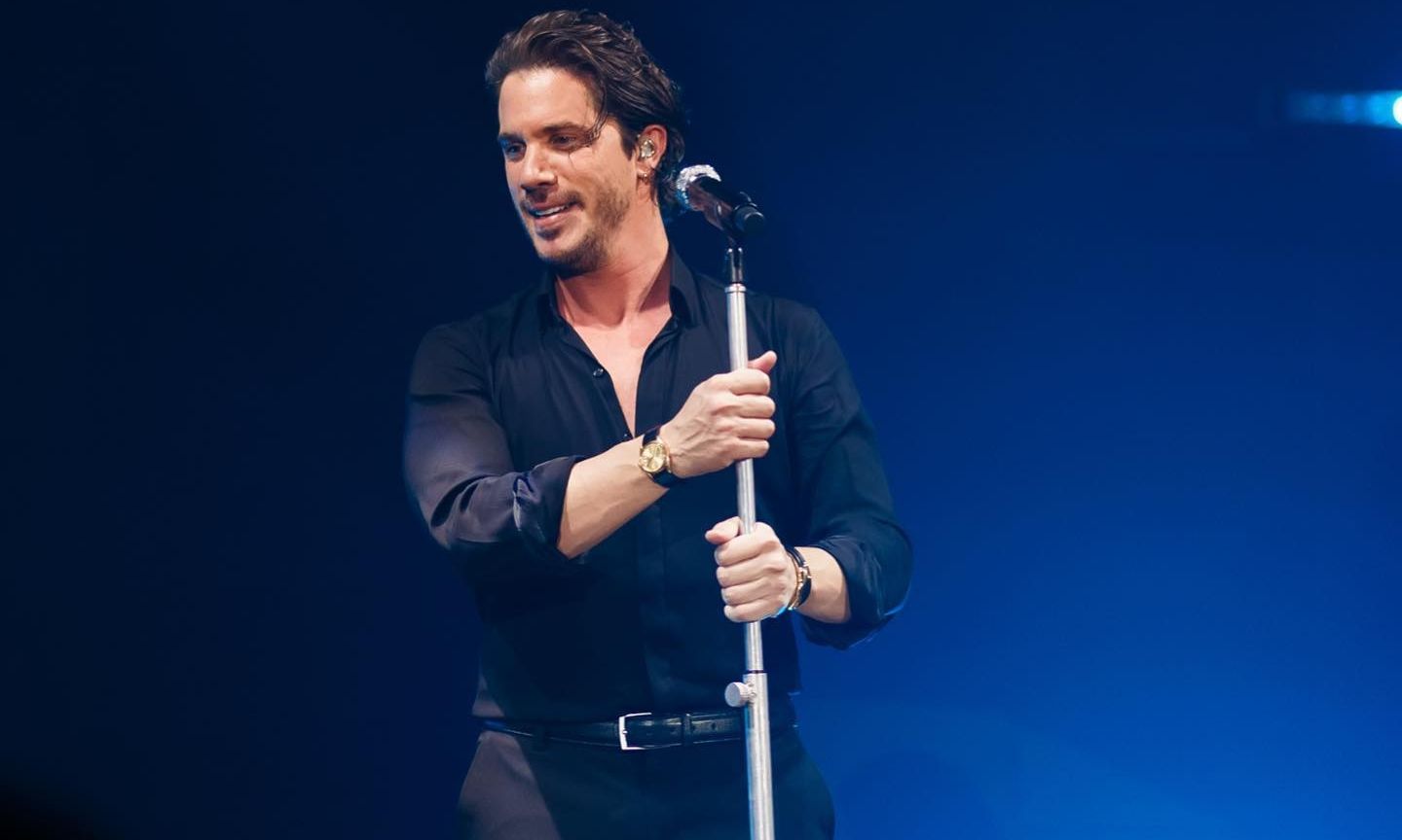 Ο Νίκος Οικονομόπουλος τραγουδάει στη σκηνή και πλησιάζει μια θαμώνα.