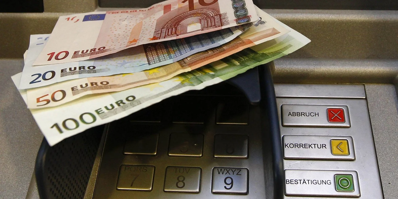 Χρήστης που πραγματοποιεί ανάληψη χρημάτων από ΑΤΜ χρησιμοποιώντας το κινητό του τηλέφωνο αντί για κάρτα