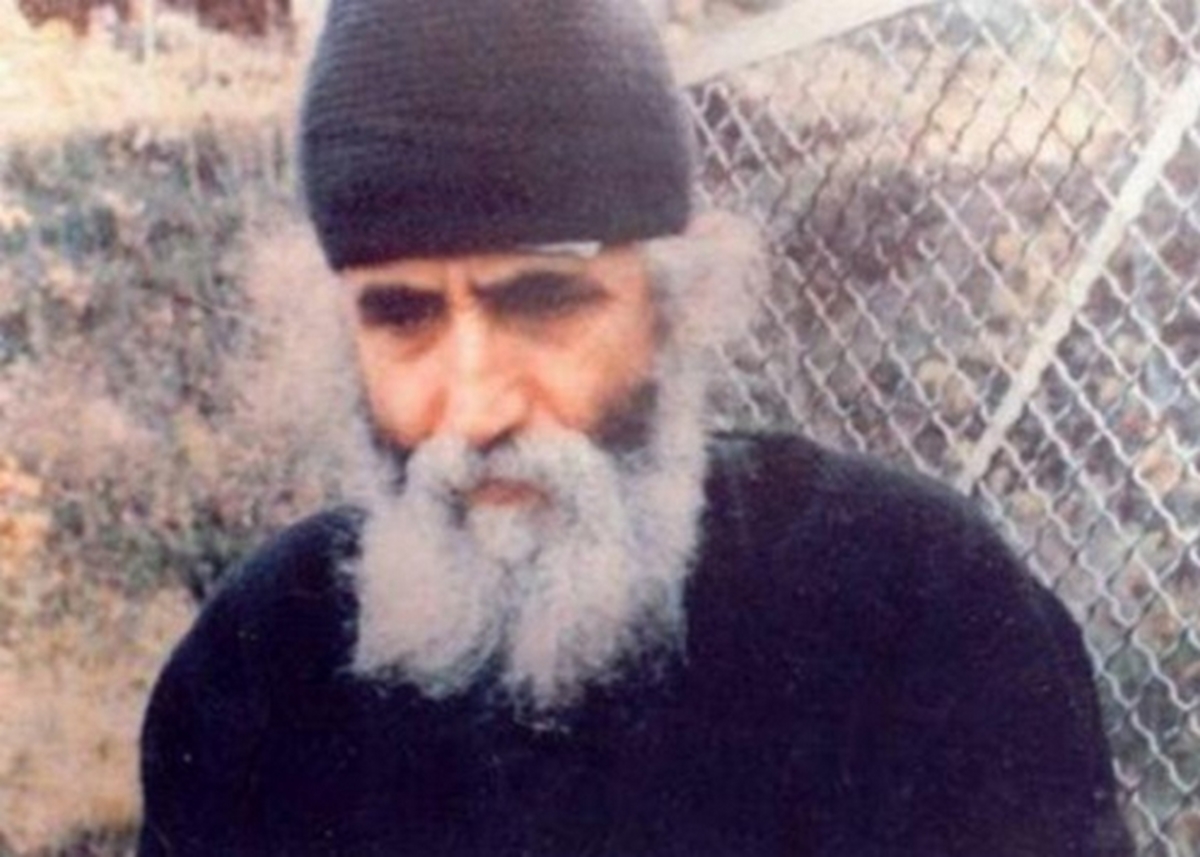 Εικόνα του Αγίου Παϊσίου του Αγιορείτη με φόντο πνευματικά χειρόγραφα και χάρτη της Μέσης Ανατολής