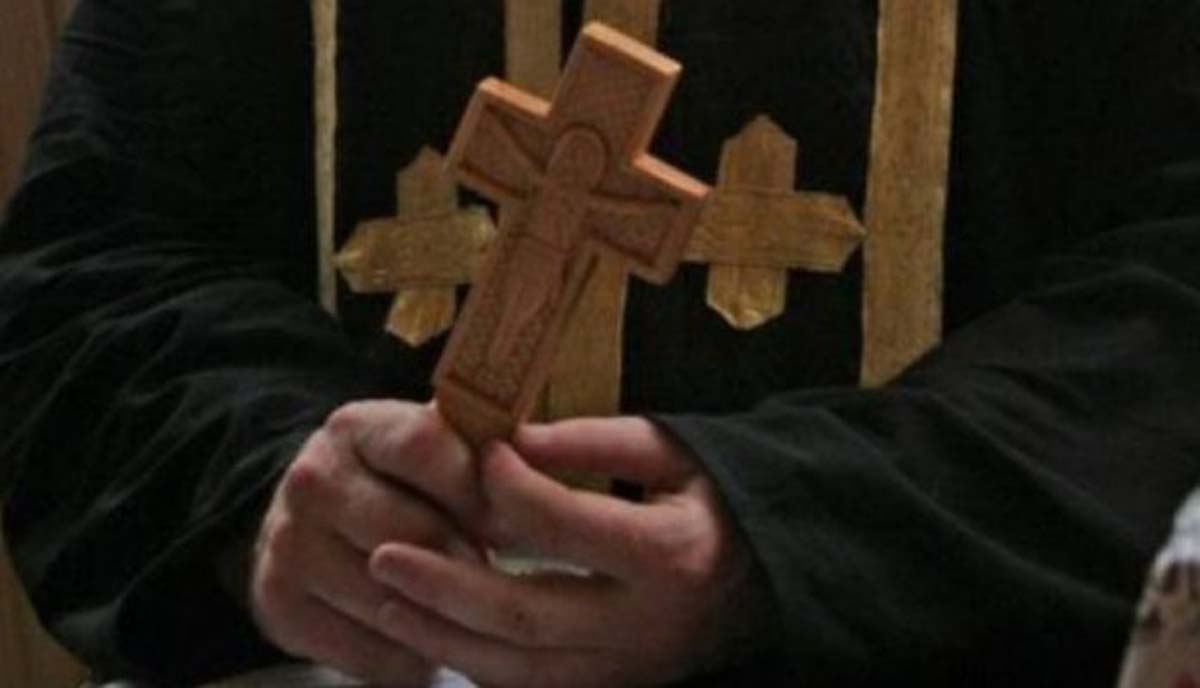 Ένας εξορκιστής ιερέας κρατάει σταυρό κατά τη διάρκεια πνευματικής μάχης