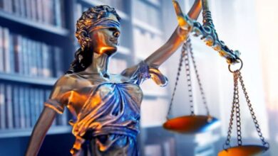 Σφυρί δικαστή πάνω σε έδρα δικαστηρίου σε σκοτεινό φόντο