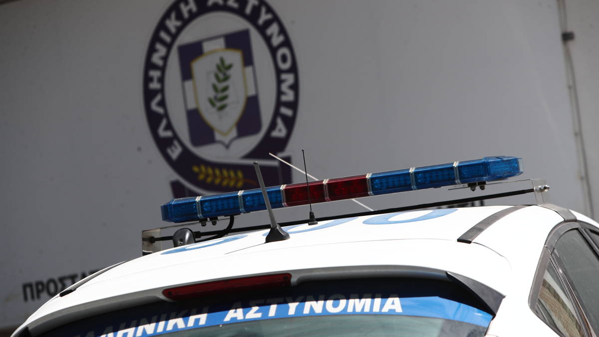 Εξωτερική όψη αστυνομικού τμήματος με περιπολικό και διακριτικά της Ελληνικής Αστυνομίας σε πένθιμο φόντο
